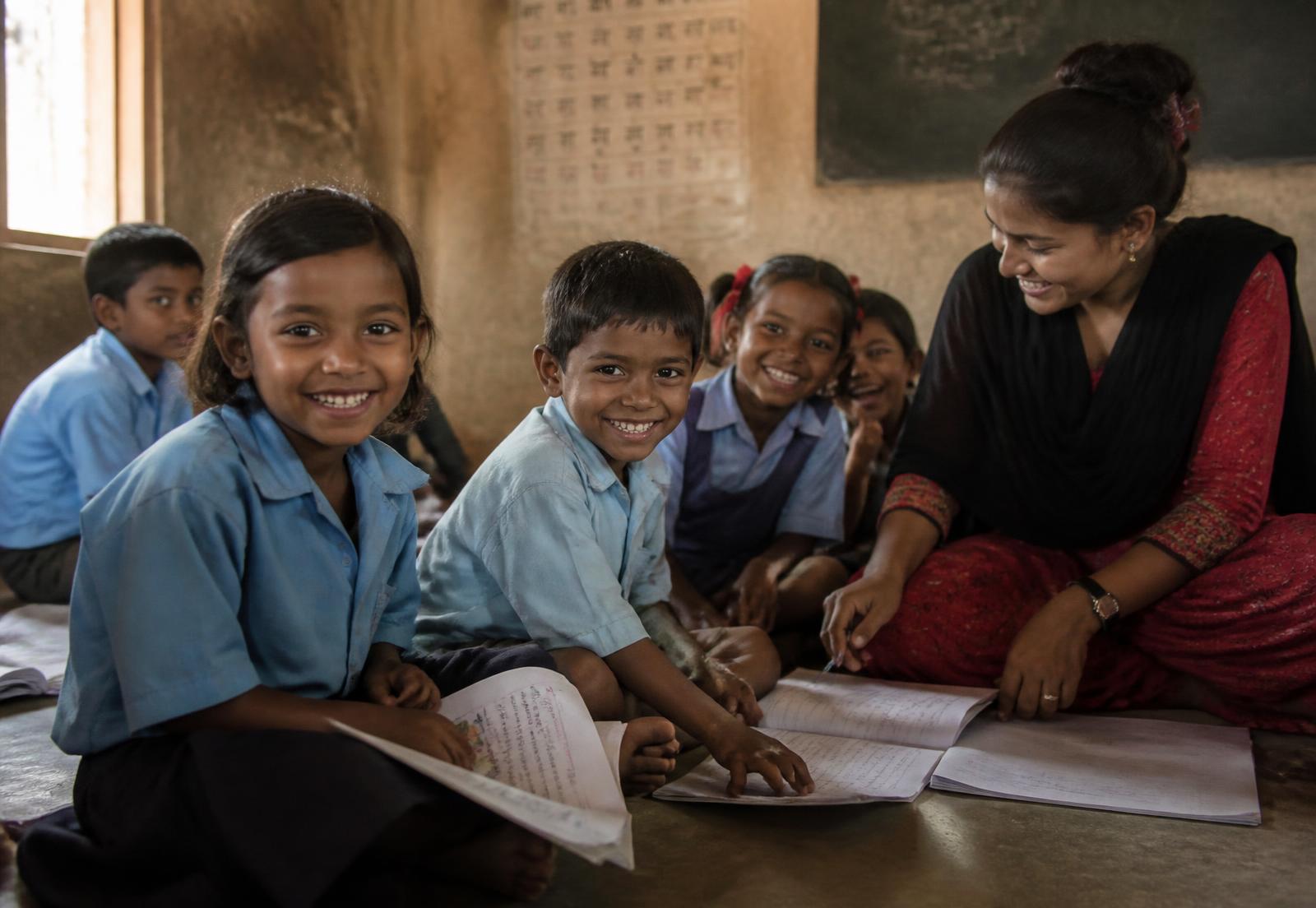 Children learning together with their teacher in a village classroom